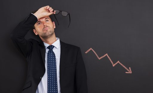 Worried businessman with sign of decreased profit